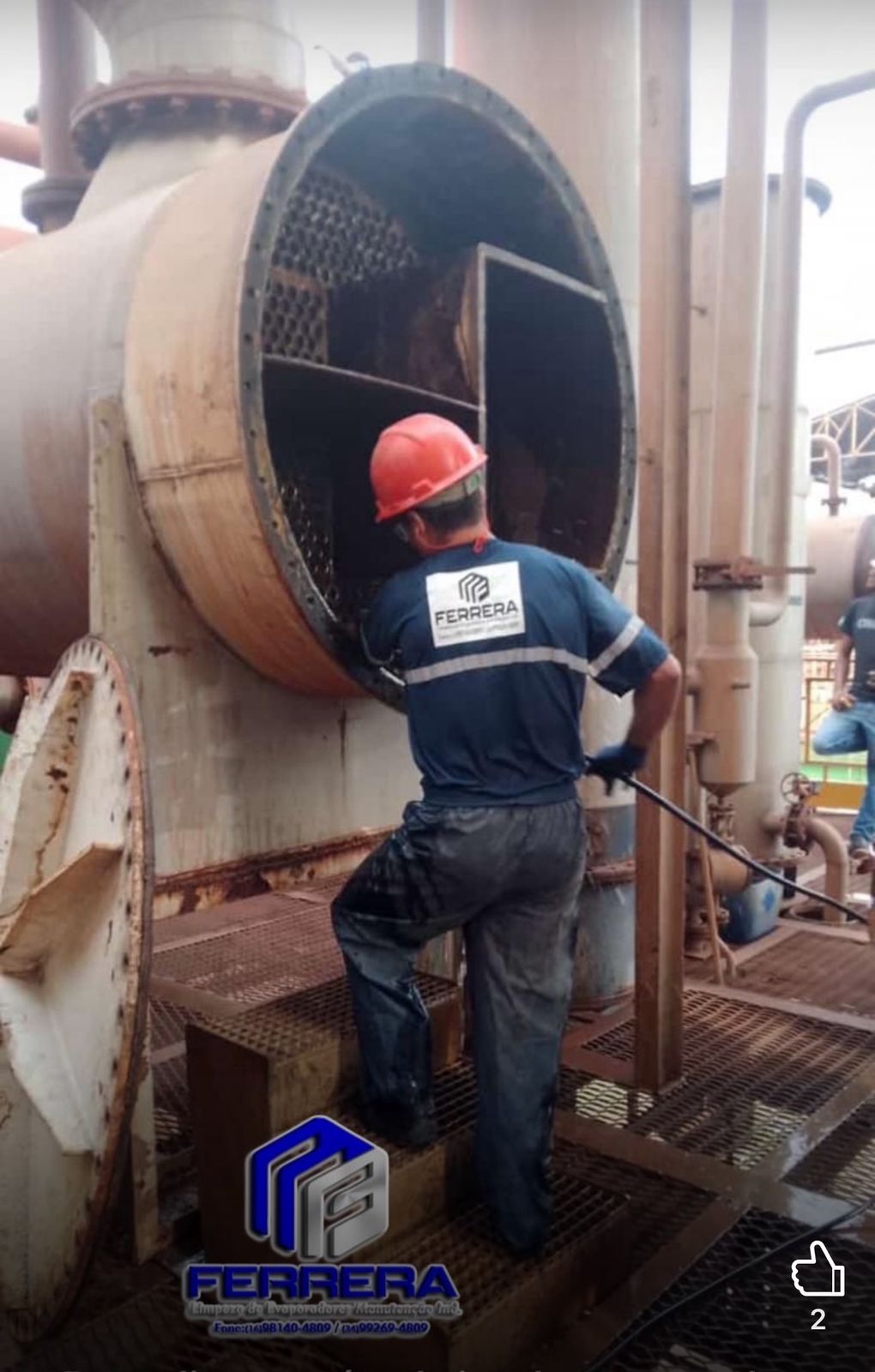 Técnico da Ferrera inspecionando e limpando o interior da placa tubular de um grande trocador de calor ou evaporador industrial.