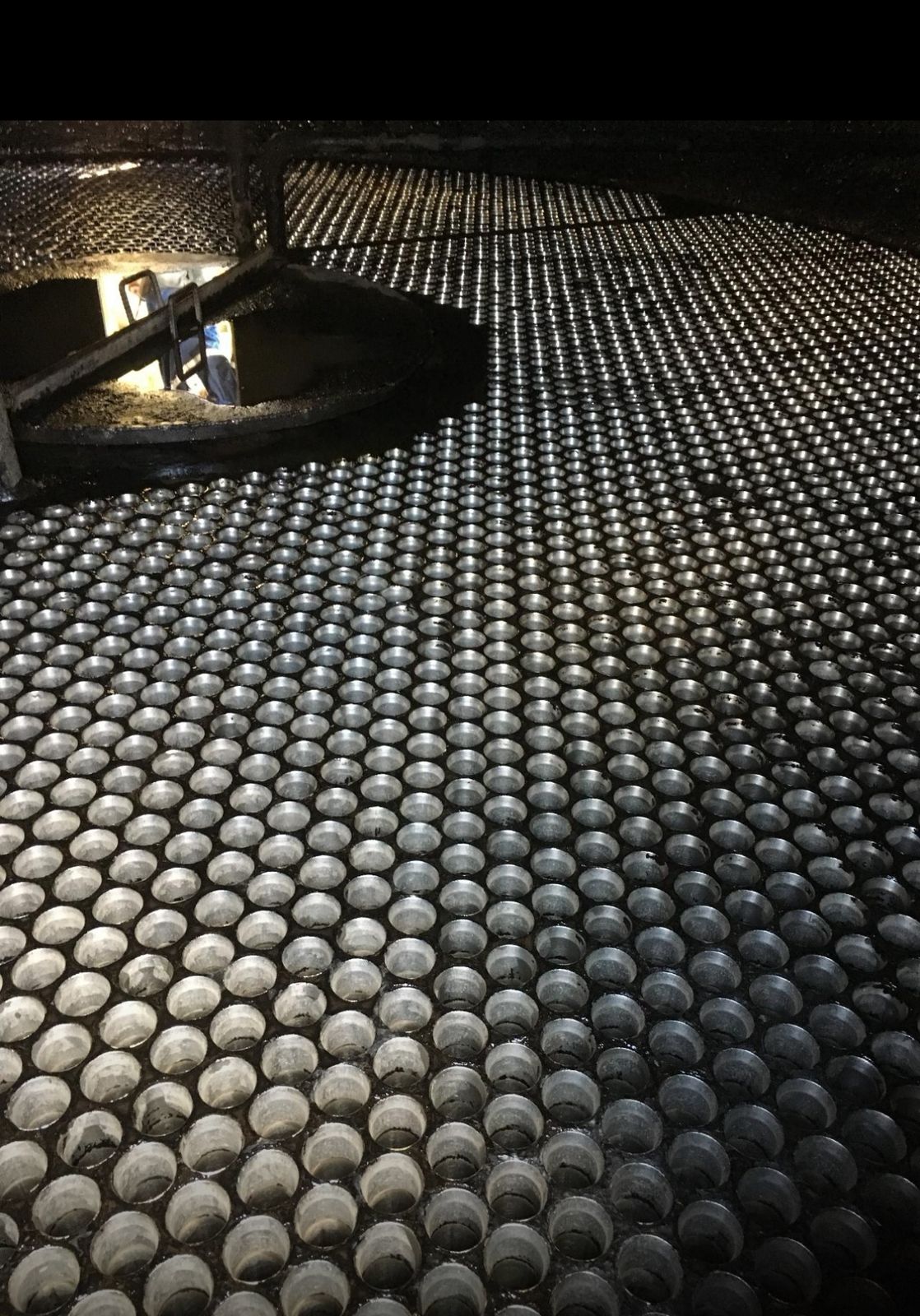 Vista em close-up de uma placa tubular de evaporador completamente limpa, mostrando a matriz de orifícios brilhantes para inserção dos tubos.