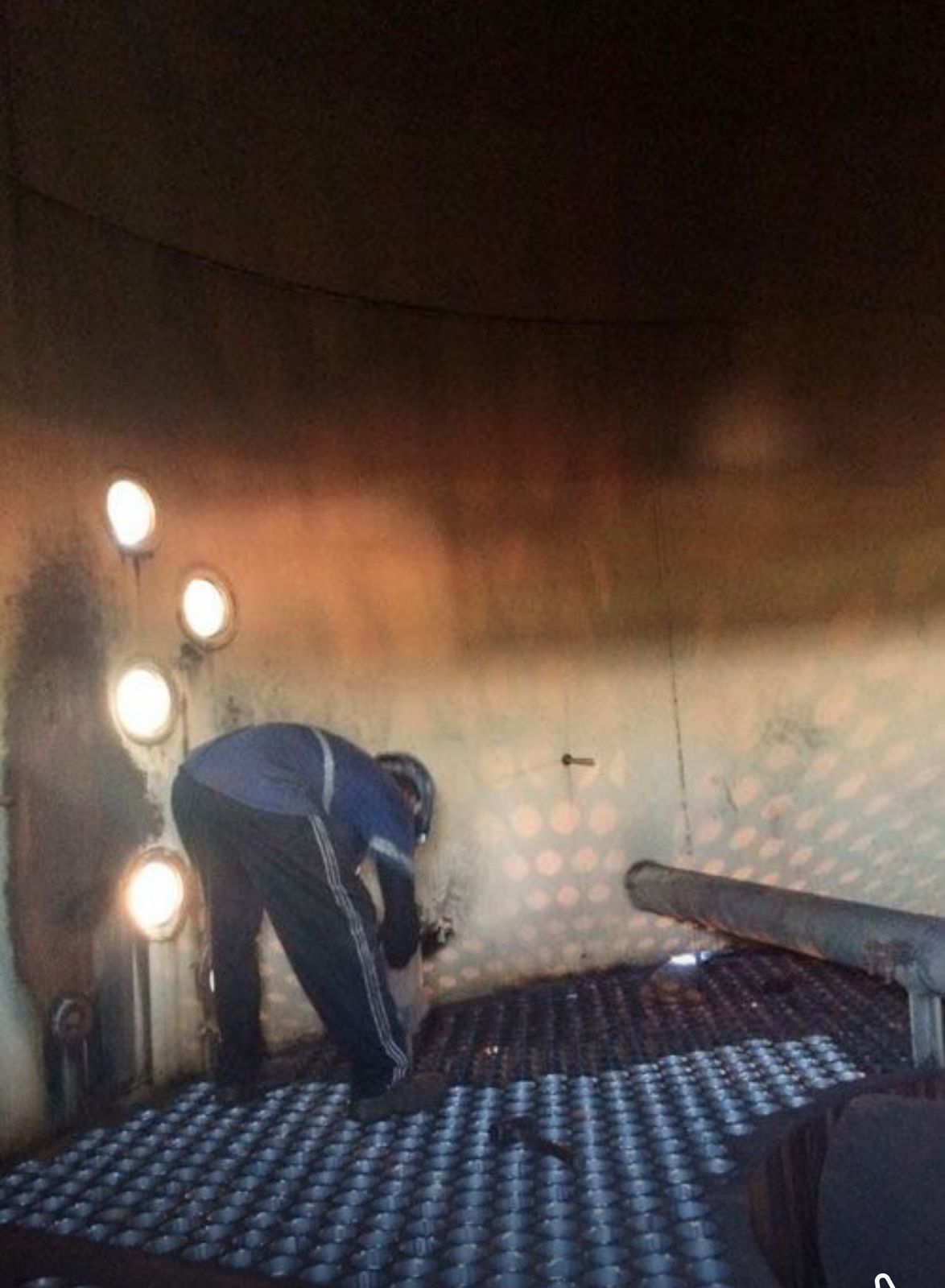 Técnico realizando inspeção ou manutenção em ambiente confinado, dentro de um vaso de pressão ou evaporador.